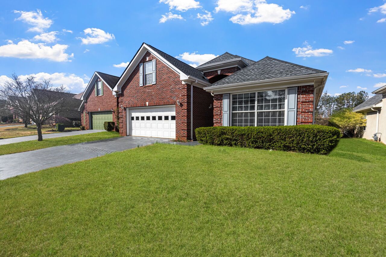 Well-kept residential lawn in front of a brick home